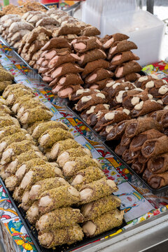 Homemade sweet pastry cannolo sfoglie filled with almond, pistachio, lemon, vanilla, chocolate cream on food market in Palermo, Sicily, Italy