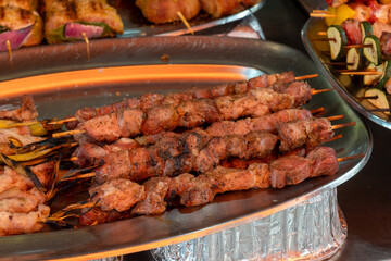 Delicious fresh cooked street food on daily food market in Palermo, Sicily, travel destination, food tourism Italy, variety of roasted, grilled fish, sausage , meat, vegetables served snacks, dish
