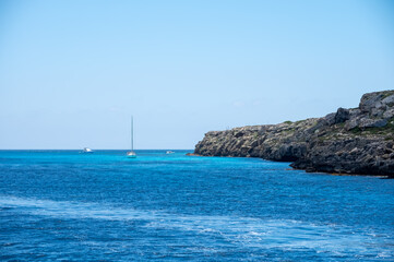 Boat trip and view on coastline of Favignana island with shallow bays with clear turquoise water, tuff rocks, abandoned quarries, caves, Egadi Islands near Sicily, Italy
