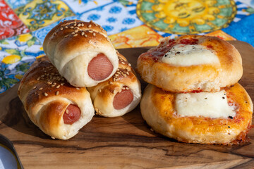 Fresh baked bread, pizza, focaccia or pizzetta with tomatoes, vegetables, sausage and cheese, street food in Palermo, Sicily, Italy, served outdoor for lunch