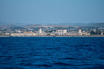 Fototapeta premium View on Saline di Trapani e Paceco Culcasi, brackish lagoon and nature reserve on Sicily, Italy, unique ecosystem with shallow, warm water, salt pans, and ancient windmills.