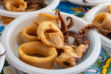 Delicious fresh cooked street food on daily food market in Palermo, Sicily, travel destination, food tourism Italy, variety of raw, roasted, grilled fish, seafood, calamari, sea urchins