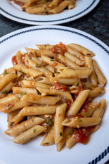 Italian everyday food, cooked pasta penne with tomatoes sauce, garlic and parsley