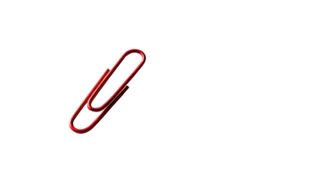 Red paperclip isolated on a black background with dramatic lighting