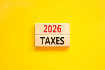 2026 taxes new year symbol. Concept words 2026 taxes on beautiful wooden blocks. Beautiful yellow paper background. Business and 2026 taxes new year concept. Copy space.