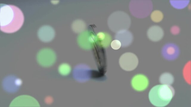 Human finger flicking euro coin flipping onto rim, spinning wobbling on grey surface for physics