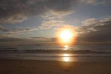 Sunrise from the Sea: Sun Peeking Out from Behind the Clouds