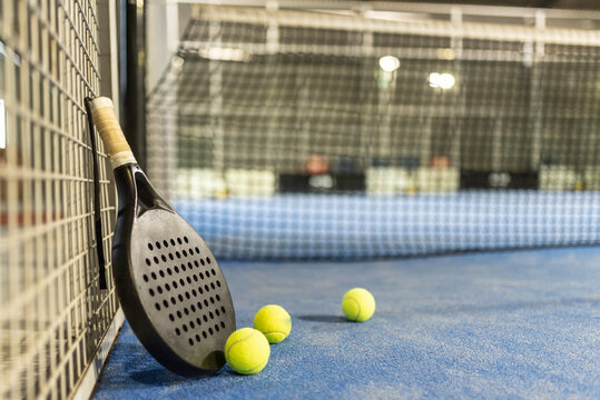 Paddle tennis racket and balls in court