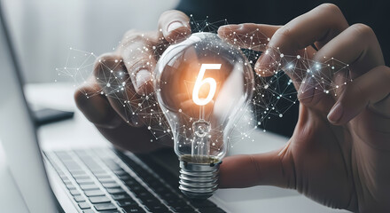 A person holds a glowing lightbulb with the number five inside, symbolizing ideas, innovation, and creative problem-solving in business.