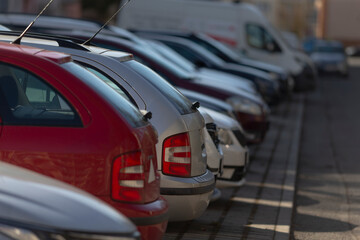 car near residence, red hatchback parked outside apartment, compact red hatchback parked on urban street corner, red hatchback stationing outside residential apartment along paved pathway at night