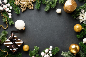 Christmas decorations and spruce tree at black background.