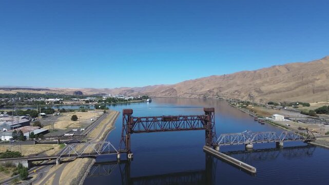 Railroad lift bridge over the Snake River in Lewiston Idaho. Flyover shot of the bridge in a high desert setting with a calm Snake River below.