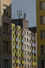 photographer captures vibrant urban landscape, street photographer captures lively city with shadows and colors, vivid street scene featuring colorful buildings and striking shadows at city outskirts