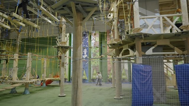Visitors walking on rope bridges in adventure park. Creative