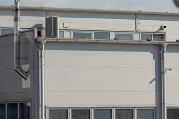 industrial exposed pipes, white industrial wall showcasing exposed ventilation pipes and fittings, practical industrial aesthetic featuring exposed ventilation systems and utility architecture