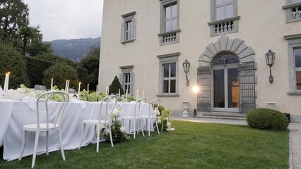 Elegant wedding reception table setting in front of villa. Action