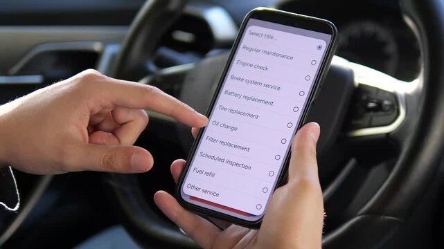 A car owners hands use a dedicated mobile application to record vehicle maintenance details, selecting appropriate data fields to document the service history. This practical scene is perfect for