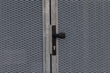 locked metal mesh gate with heavy padlock, rugged security detail and industrial finish, close framing shows grid pattern, latch and reinforced seam conveying protection and restricted access