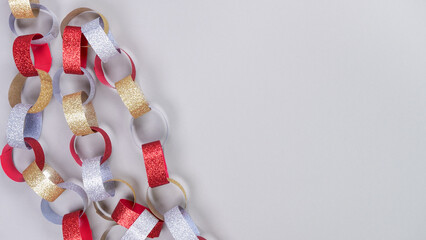 Colorful Christmas garland made of red, silver, and gold paper chains, creating a festive atmosphere for holiday celebrations and decorations