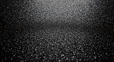 Close-up view of a textured surface, exhibiting a myriad of small, reflective specks against a deep black backdrop, creating a captivating visual effect.