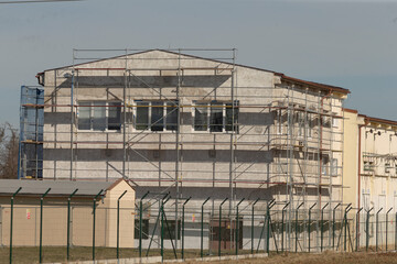 Obraz premium exterior fixing with safety barriers, repairing outside using scaffolding and protective barriers, performing external repairs on structures with scaffolding and safety barriers in place