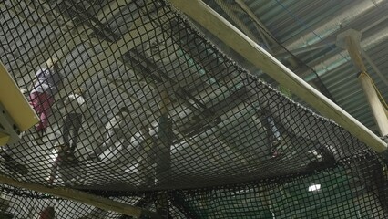Kids navigating rope bridge in indoor playground. Creative