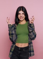 Young woman playfully displaying a fierce expression against a pink background