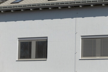 stucco facade details, urban residential building facade description, minimalist white stucco residential exterior with windows, clean white plaster with windows and shadows in urban setting