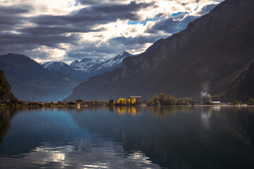 Swiss Alps lake landscape with reflection, snow-capped mountains, dramatic sky, nature, travel, tranquility, scenic view, autumn colors, Interlaken, photography.