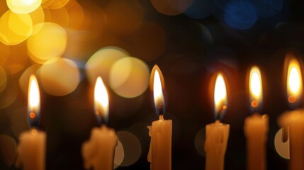 Row of candles are lit and are in a blurry background
