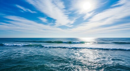 Fototapeta premium A vast expanse of ocean waves meeting a vibrant, cloud-filled blue sky, showcasing the peaceful beauty of the natural world.