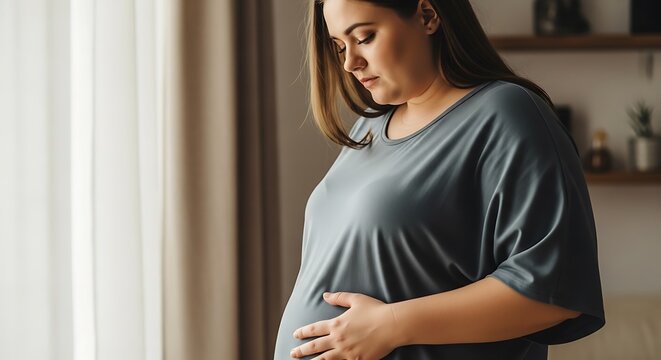 Expectant mother tenderly cradling her pregnant belly in a quiet moment of reflection at home
