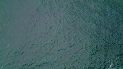 Turquoise ocean water rippling in slow motion top view. Picturesque blue waves