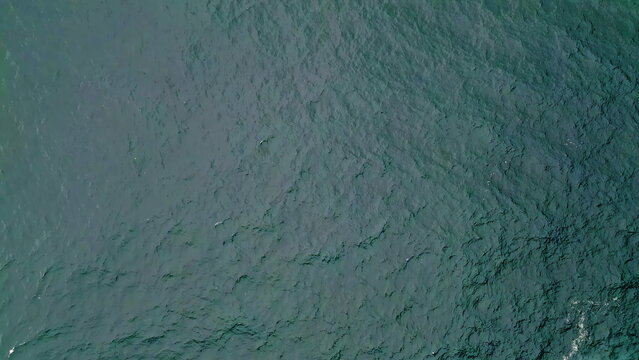 Turquoise ocean water rippling in slow motion top view. Picturesque blue waves