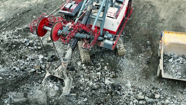 Excavator loading rocks into dump truck in quarry. Stock clip
