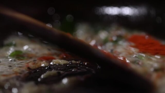 Adding spices while cooking. Closeup shot of cooking in pan.