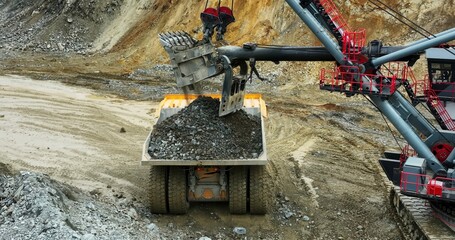 Excavator loading dump truck in open pit mine. Stock clip