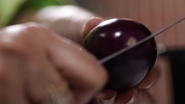 closeup shot of Cutting egg plant with knife. Preparing egg plant for cooking.
