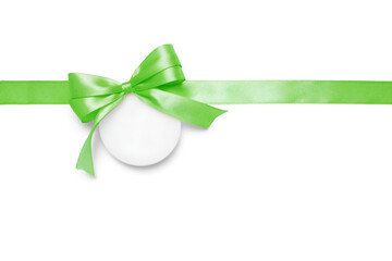 Isolated green satin ribbon with decorative bow and round gift tag on white background. Ideal...