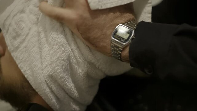 Hairdresser drying man's hair with white towel. Clip
