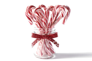 Festive candy canes in a glass jar with a red ribbon holiday treat for Christmas and winter celebrations isolated on white