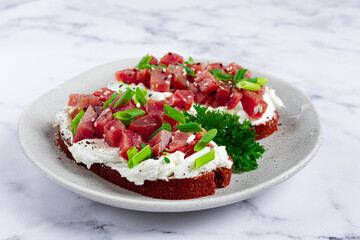 sandwiches, rye bread with cream cheese, sliced tuna fillet with green onions, breakfast, on a marble table, homemade,