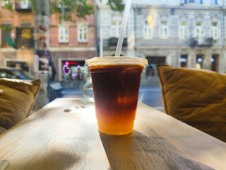 Bumble coffee drink on a wooden table, iced bumble in cafe. Bumble, or Orange Espresso is a refreshing mocktail drink that combines espresso or coffee with orange juice