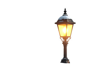 Fototapeta premium Classic black street lamp with snow on top glowing brightly.