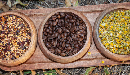 Coffee beans and dried tea in a wooden bowl. Nobody
