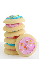 closeup stack of colorful sugar cookies with sprinkles on white