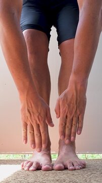 Fit man stretching hamstrings and touching his toes.Vertical video