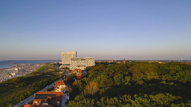 Rostock, Germany – August 17, 2024: Aerial view of Warnemünde Beach on the Baltic Sea at sunset. Hotels, beach chairs, and promenade along the scenic coastline.