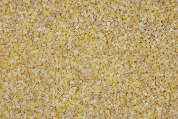 A close-up view bulgur. The textured abstract background