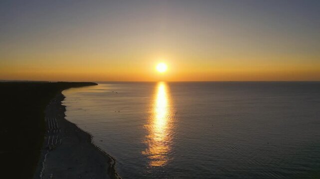 Rostock, Germany – August 17, 2024: Aerial view of Warnemünde Beach on the Baltic Sea at sunset. Hotels, beach chairs, and promenade along the scenic coastline.